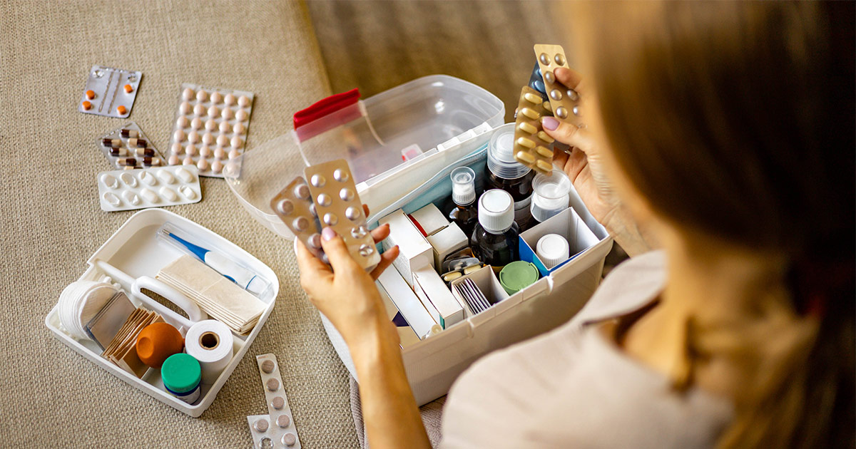A woman organizes her medication into a container before a long distance move. 