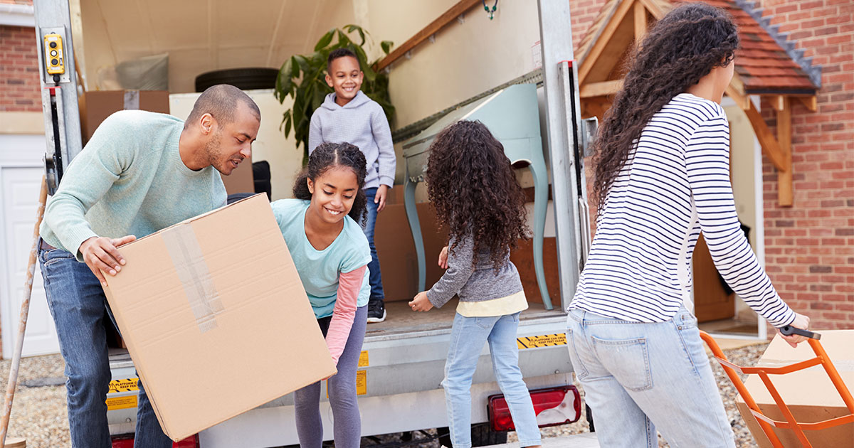 A family of five unloads a small rental moving truck after their move. They have chosen do to a DIY move. They prepared in advance and avoided common moving mistakes along the way.