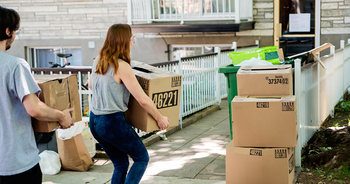 A couple stacks boxes and bags outside of their Chicago apartment for their long distance move out of Chicago.