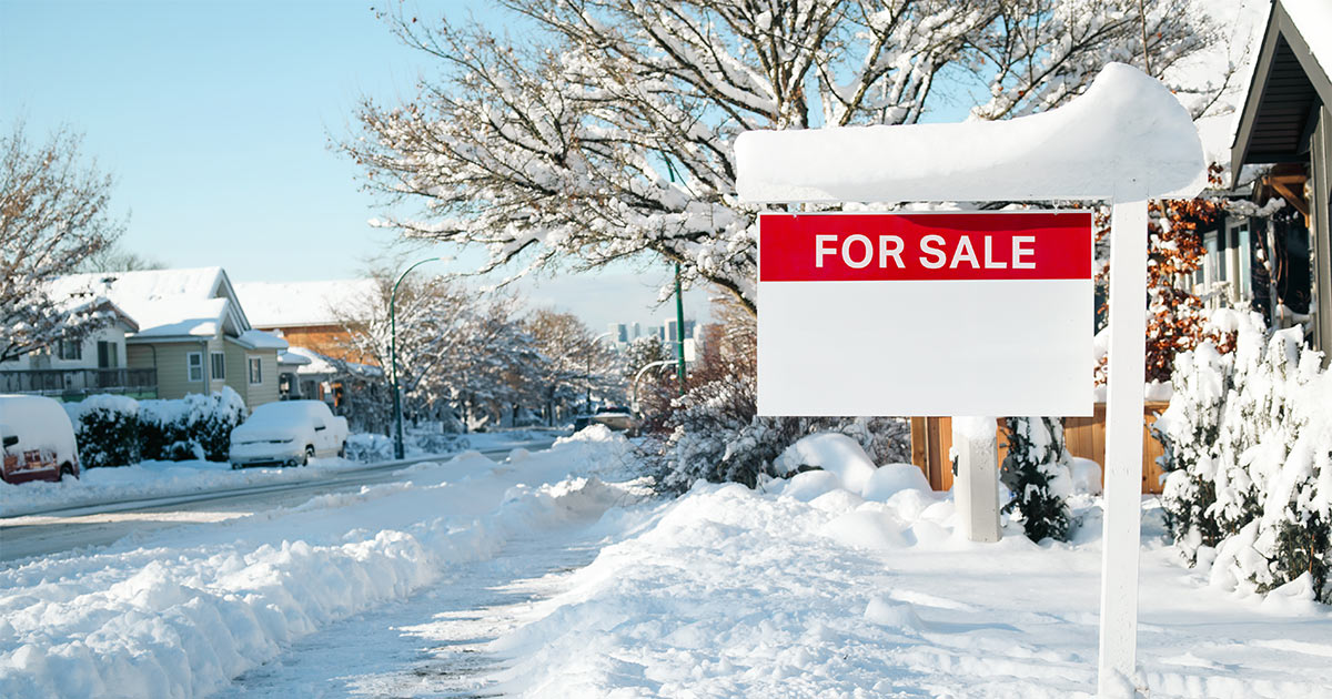 A "for sale" sign in front of a house, on a snow-covered street in Illinois.