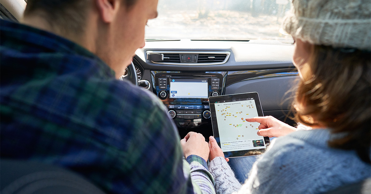 A couple discuss their long distance move out of Illinois and review a map on a tablet.