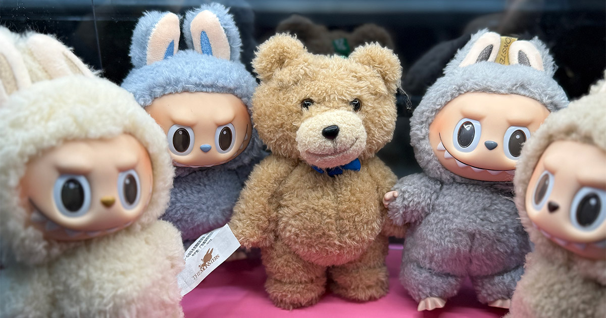 Five Labubu dolls are displayed in a lit display case for safe storage.
