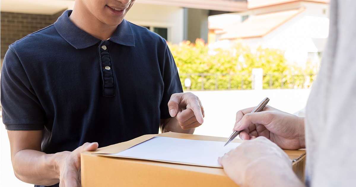 Someone signs for their delivery for their long distance move outside their new home. 