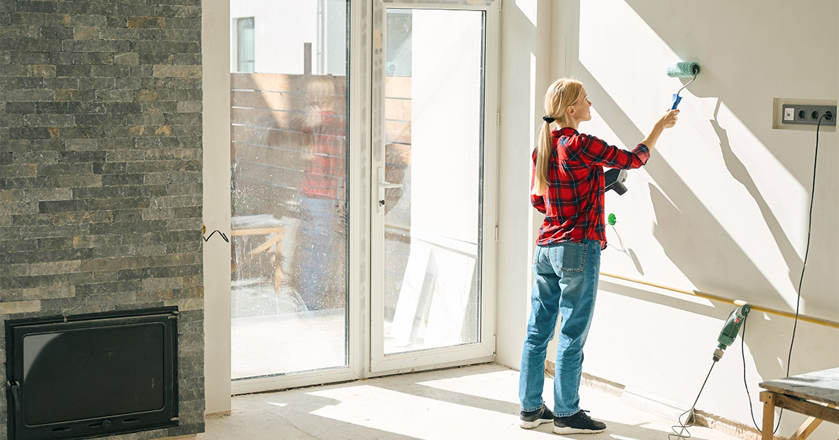 A woman begins to paint a room in her house with a new color to increase the resale value of her home.