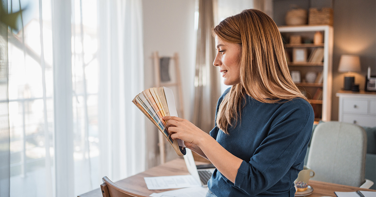 A woman picks out paint colors to boost the resale value of a home. 