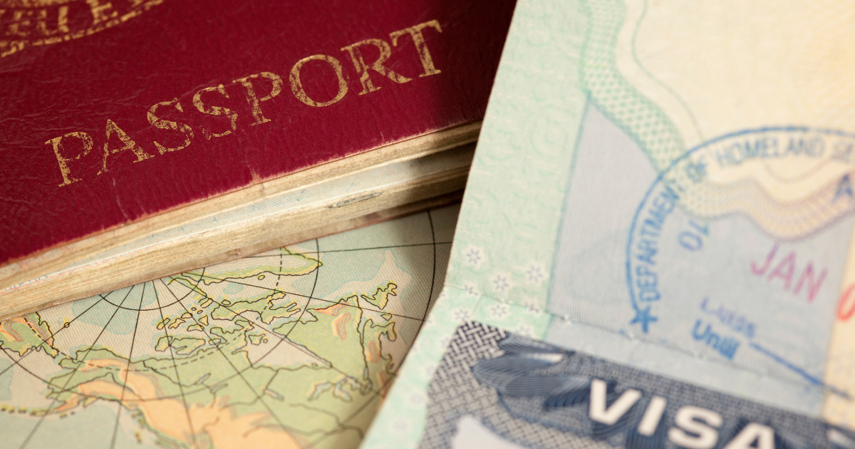 A closeup photo of a United States passport, a United States visa, and a world map.