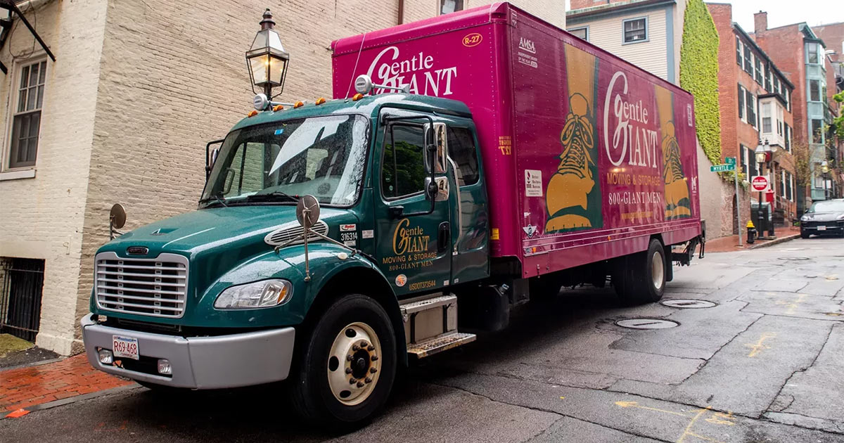 A Gentle Giant Moving Company moving truck parked in a city alleyway, before a long distance move.