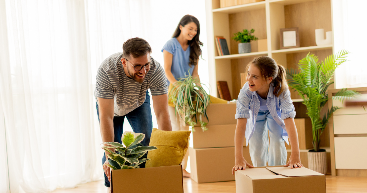 Parents and their child happily unpack boxes in their new home after a long distance move. They used a BBB accredited moving company. 
