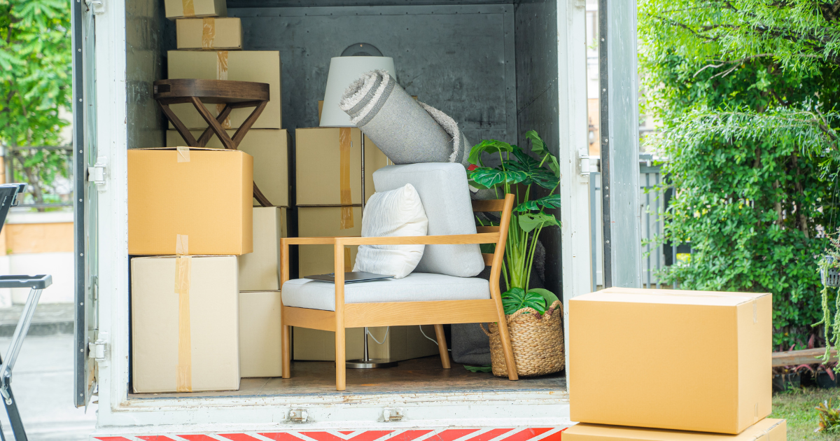 A moving truck is open with moving boxes and furniture inside. It is for a South Florida moving company that is completing a long distance move.