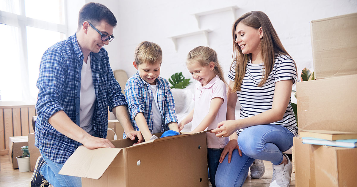 A family of four is unpacking their moving boxes in their new condominium. They have just completed a small move with the help of a full-service mover.