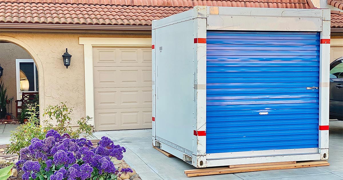 A Ubox sits in the driveway of a home. The owners of this home are getting ready to move long distance, and are using a Ubox for moving.